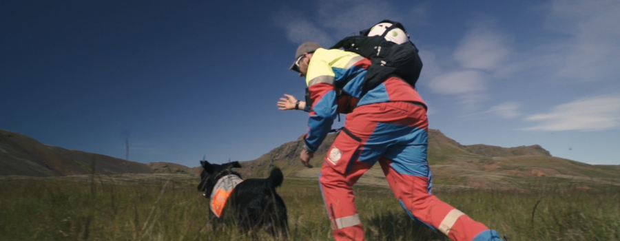 Man from björgunarsveitin and a dog running
